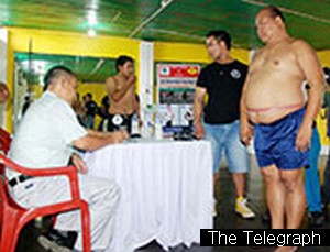 Officials take measurements of a competitor at Apunba Fitness Centre